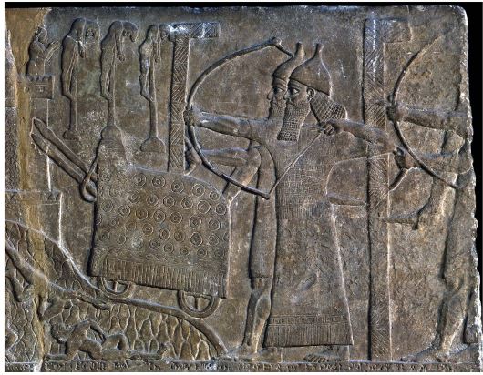 Escena de asedio con dos enormes escudos en forma de L que protegen a los soldados asirios, en un relieve del palacio de Tiglath-Pileser III en Nimrud (cortesía del Museo Británico)