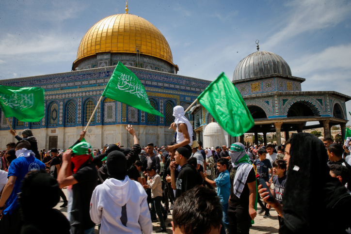 Los palestinos enarbolan banderas de Hamas después de las oraciones del Ramadán en la mezquita Al-Aqsa en el Monte del Templo en Jerusalem, el 22 de abril de 2022. Foto de Jamal Awad/Flash90.