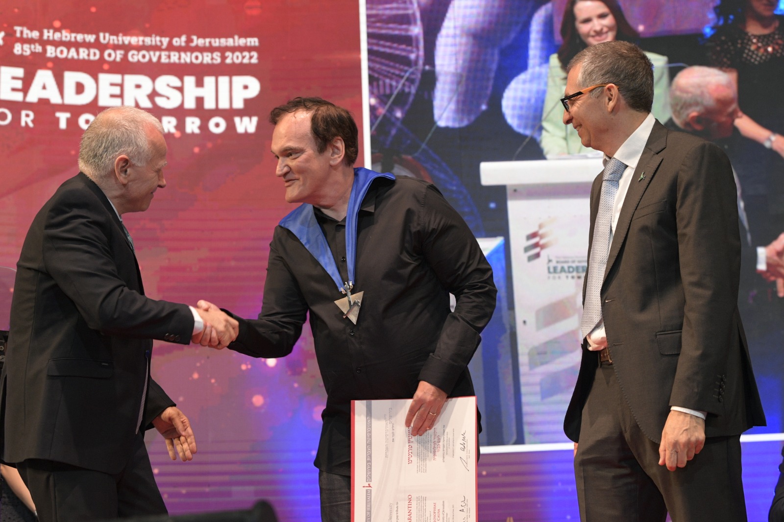 El Prof. Asher Cohen saluda a Quentin Tarantino al recibir el Doctorado Honoris Causa de la Universidad Hebrea de Jerusalem. Lo Acompaña el Rector, Prof. Barak Medina | Foto: Bruno Cherbit
